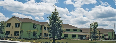 Viera Manor exterior backed by blue sky and white clouds