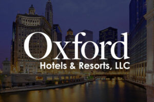 The Oxford Hotels & Resorts logo appears overtop an image of a city skyline at night